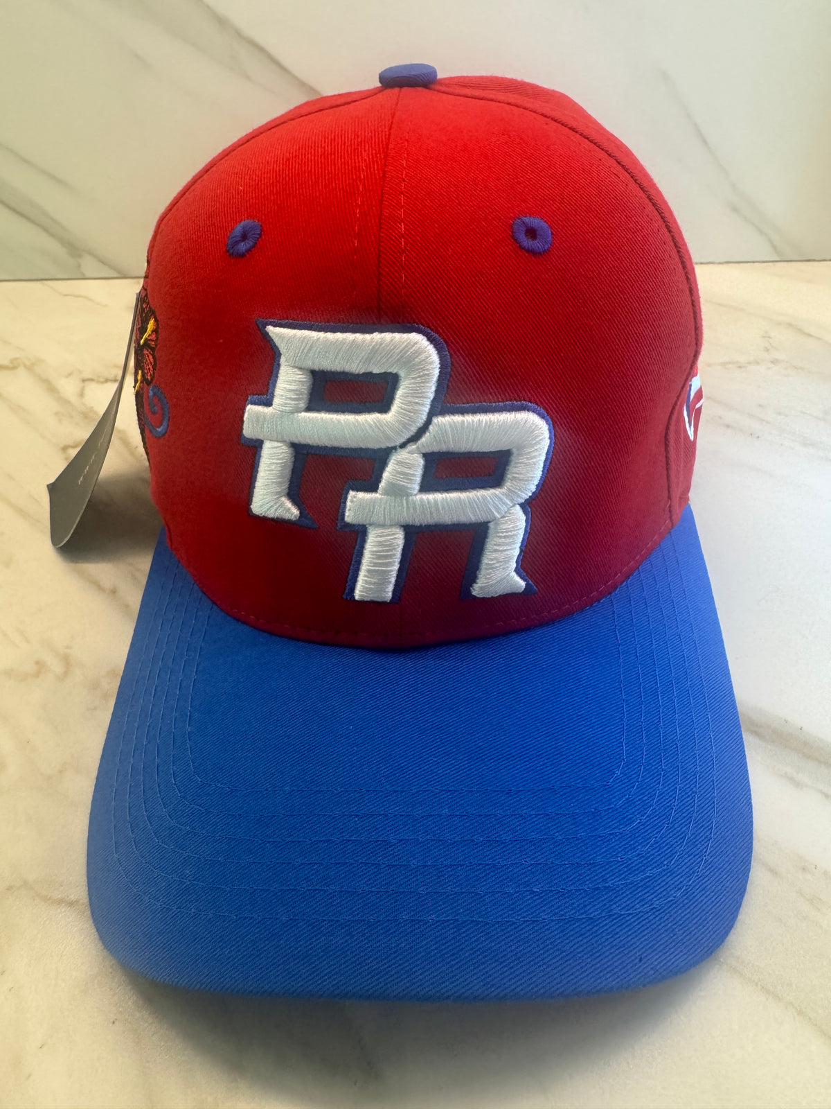 PR Heritage Snapback Hat with red crown blue curved brim and raised 3D embroidery details
