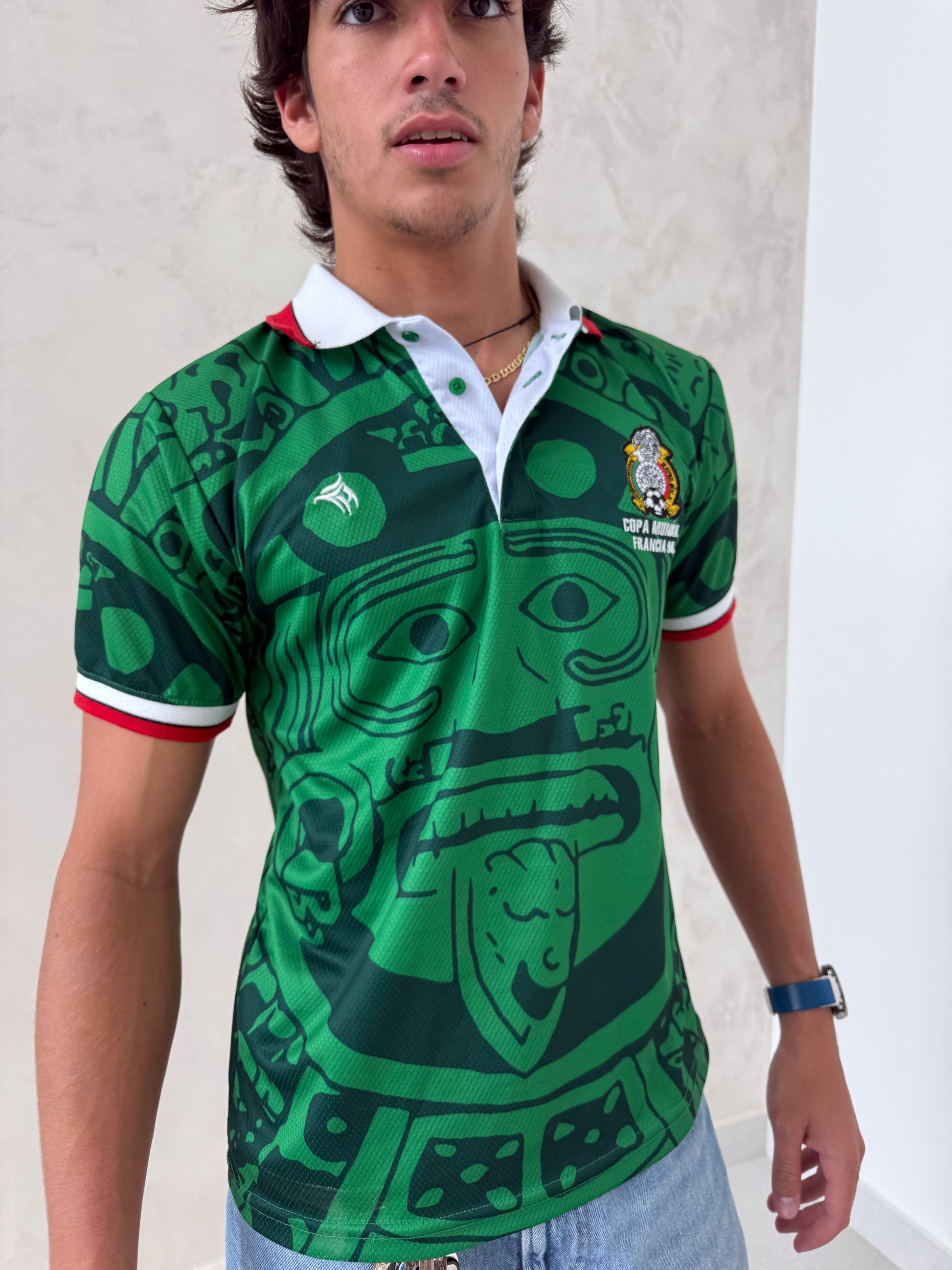 Person wearing a green sports jersey with a graphic design on a light background