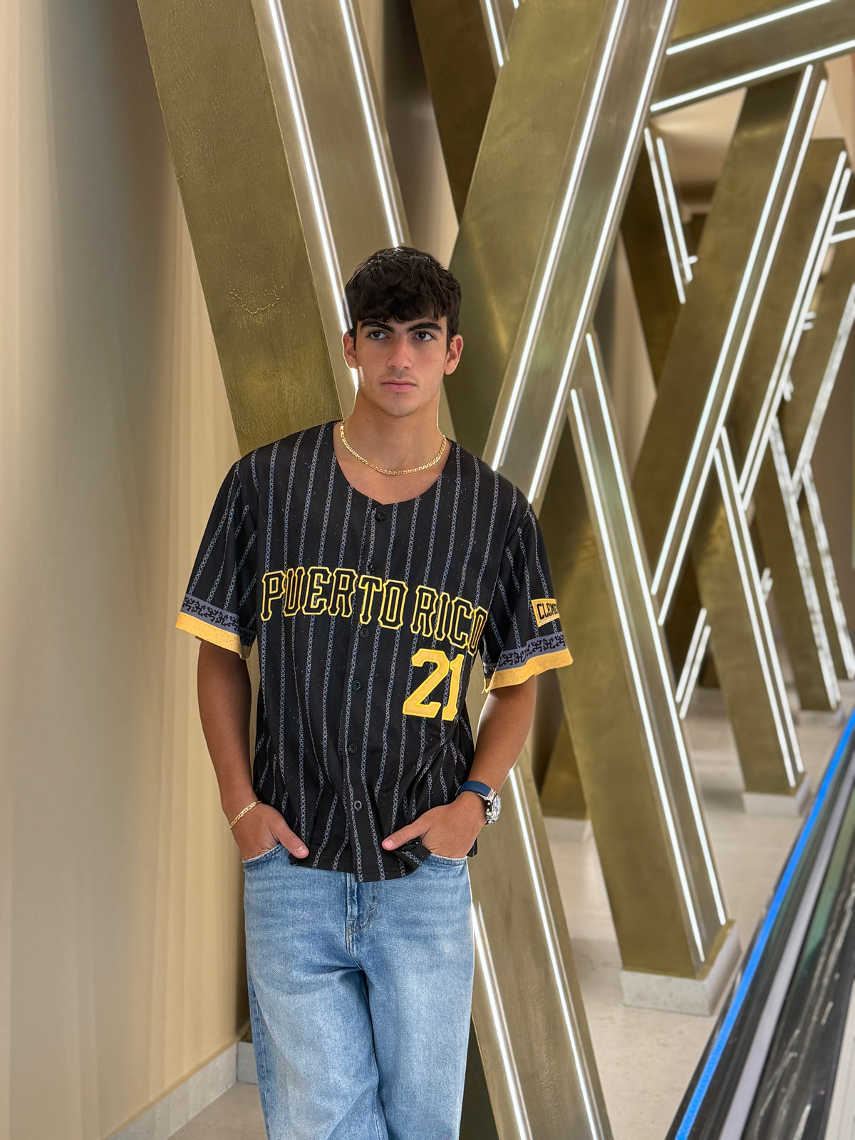 Person wearing a 'Puerto Rico' themed jersey standing in front of geometric wall art.