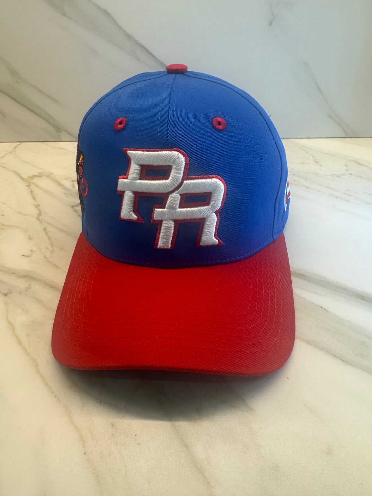 PR Heritage Snapback Hat with blue crown red curved brim and premium embroidered side artwork