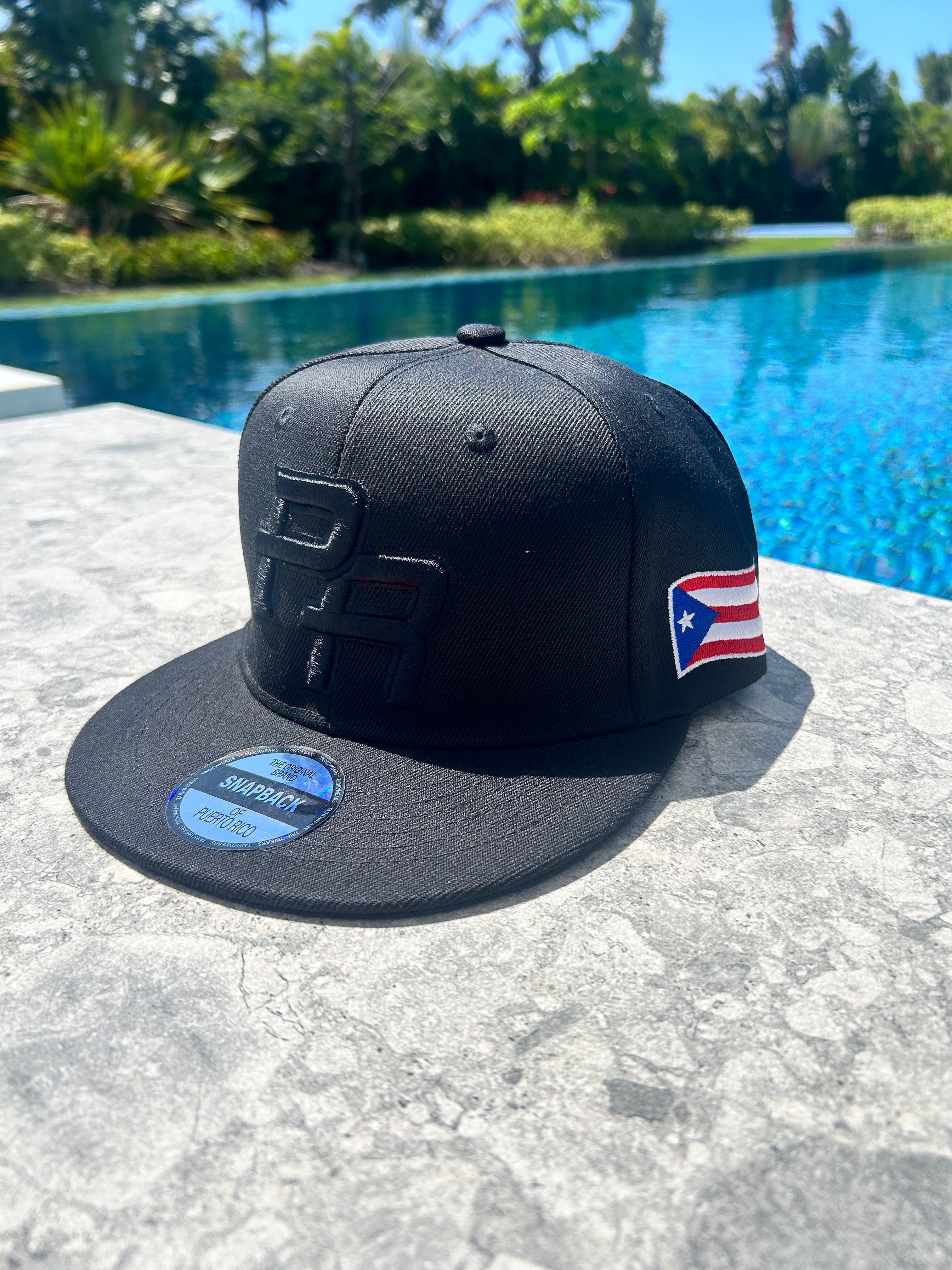 Black cap with a Puerto Rican flag design on a poolside surface