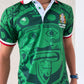 Person wearing a green sports jersey with graphic design on a light background