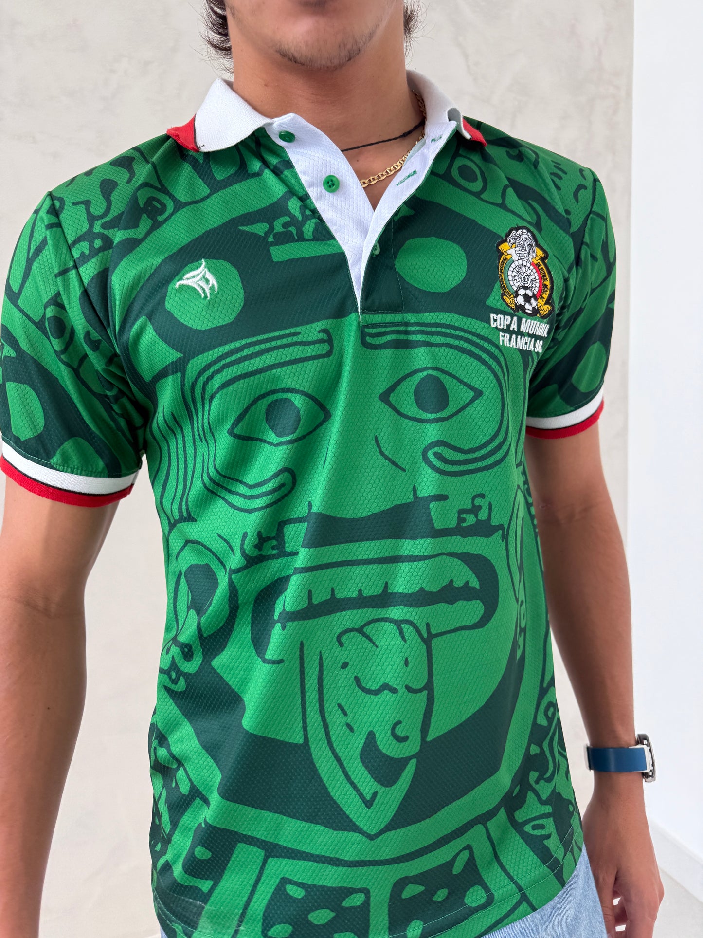 Person wearing a green sports jersey with graphic design on a light background