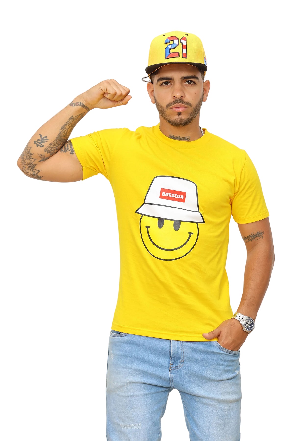 Man wearing a yellow t-shirt with a smiley face design, light blue jeans, and a colorful cap.